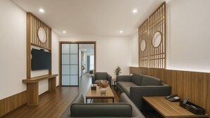 A modern hotel lobby with a wooden floor, a reception desk, a sofa, a coffee table, and a TV mounted on the wall. - Jiu Jian Tang Bo City Hotel (Ningde)