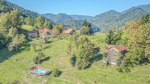 A rural landscape with houses and a swimming pool.
