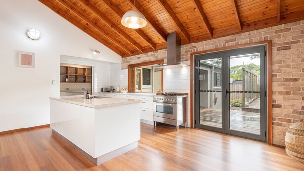 A modern kitchen with a central island, stainless steel appliances, and a wooden ceiling. - Ponderosa, a gorgeous and spacious five bedroom beach house (Blueys Beach)
