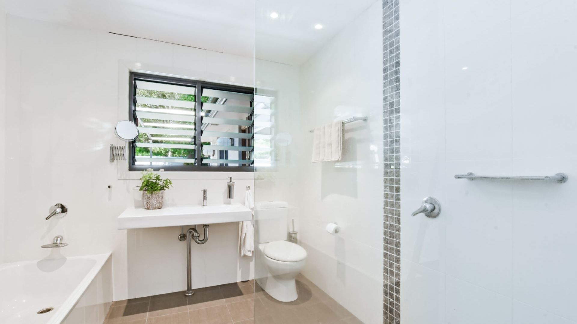 Une salle de bain moderne équipée d’une baignoire, de toilettes et d’un espace douche.