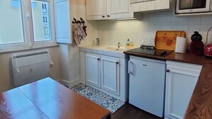 A compact kitchen with white cabinets, a microwave, and a small countertop. - 4-person Apartment near Cable Cars in Cauterets (Cauterets)
