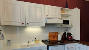 A kitchen with white cabinets, a microwave, a kettle, and a sink. - 4-person Apartment near Cable Cars in Cauterets (Cauterets)