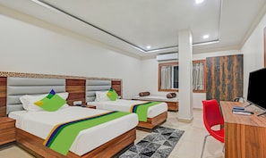 A hotel room with two beds, a desk, a chair, a TV, and a window with curtains. - Treebo Paradise Premium Rasulgarh (Bhubaneshwar)