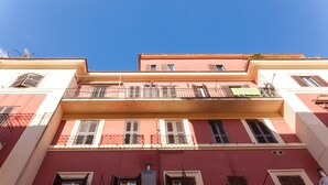 A multi-story building with balconies, windows with shutters, and a clear blue sky. - Appartamento Vaticano per 6 persone (Rome)