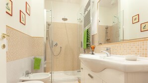 A modern bathroom with a glass shower enclosure, a white sink, and a toilet. - Appartamento Vaticano per 6 persone (Rome)