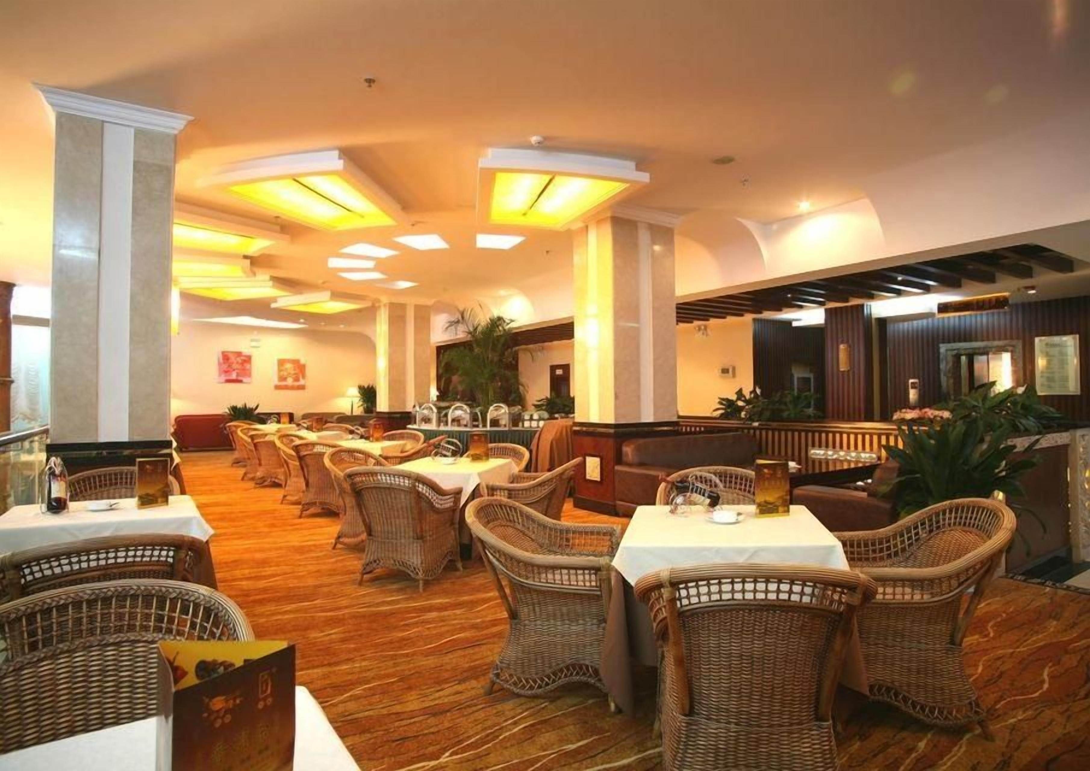 A restaurant with wicker furniture, tables, and a warm ambiance.