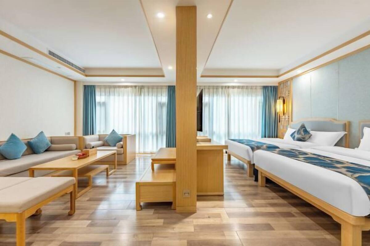 Ein Hotelzimmer mit einer Couch, einem Bett, einem Schreibtisch und einem Sessel.