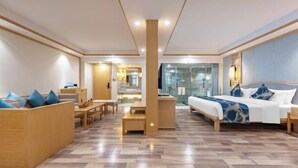 A modern hotel room with a large bed, a seating area, and a view of the city. - Jinmeng Hotel (Wenshan City)