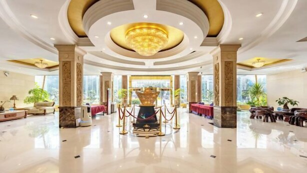 A spacious lobby with a central chandelier, marble columns, and a red carpet leading to a reception area. - Jinmeng Hotel (Wenshan City)