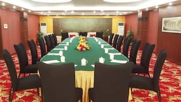 A conference room with a long table, chairs, and a floral centerpiece.