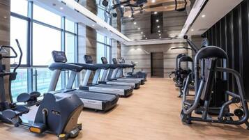 Un gimnasio con cintas de correr, elípticas y máquinas de pesas.