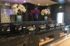 A buffet area with multiple serving stations, each with a covered food container. - Golden Sun Hotel (Lai'an)