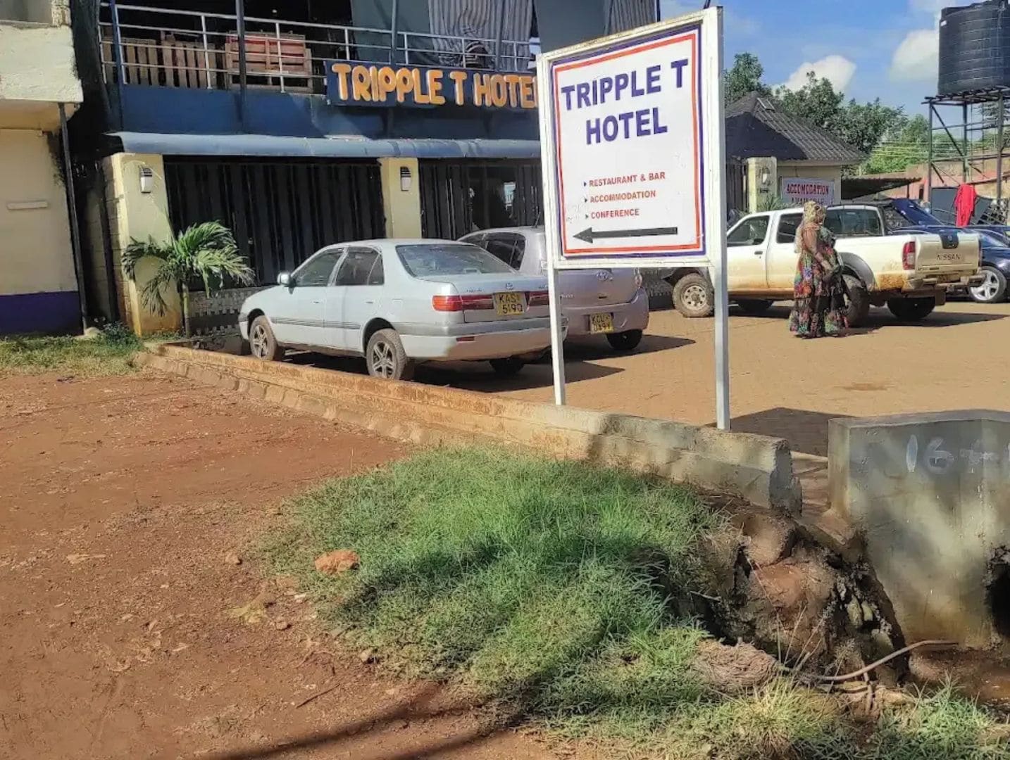 A hotel named TRIPPLE T HOTEL with a signboard indicating it offers a restaurant, bar, accommodation, and conference facilities.