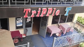 Un restaurant appelé « Tripple T » qui dispose d’une terrasse et d’un sol recouvert de carreaux bleus.