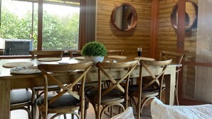 Un coin repas en bois avec une table, des chaises et une plante en pot.