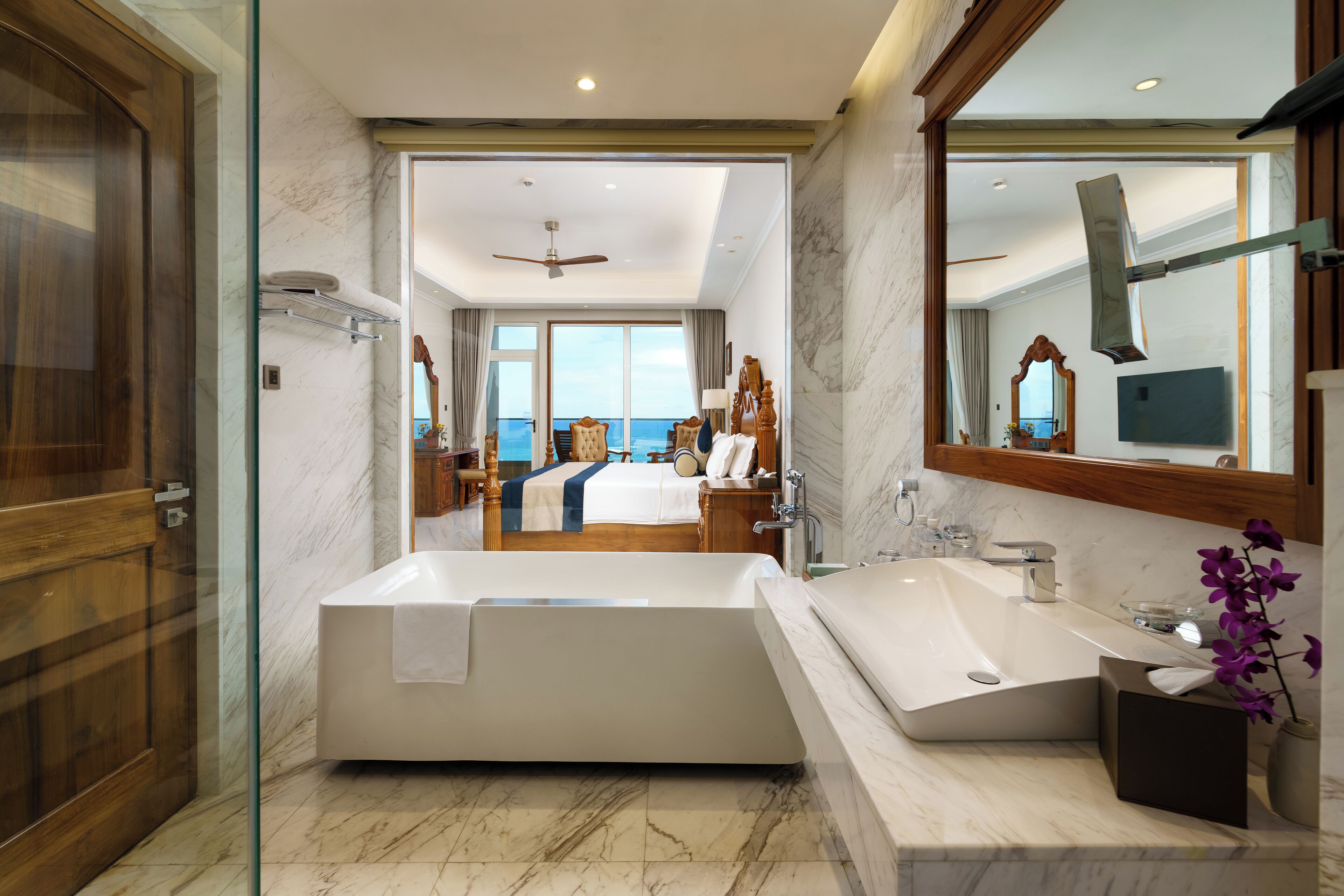 A modern bathroom with a large bathtub, a double sink, and a large mirror.
