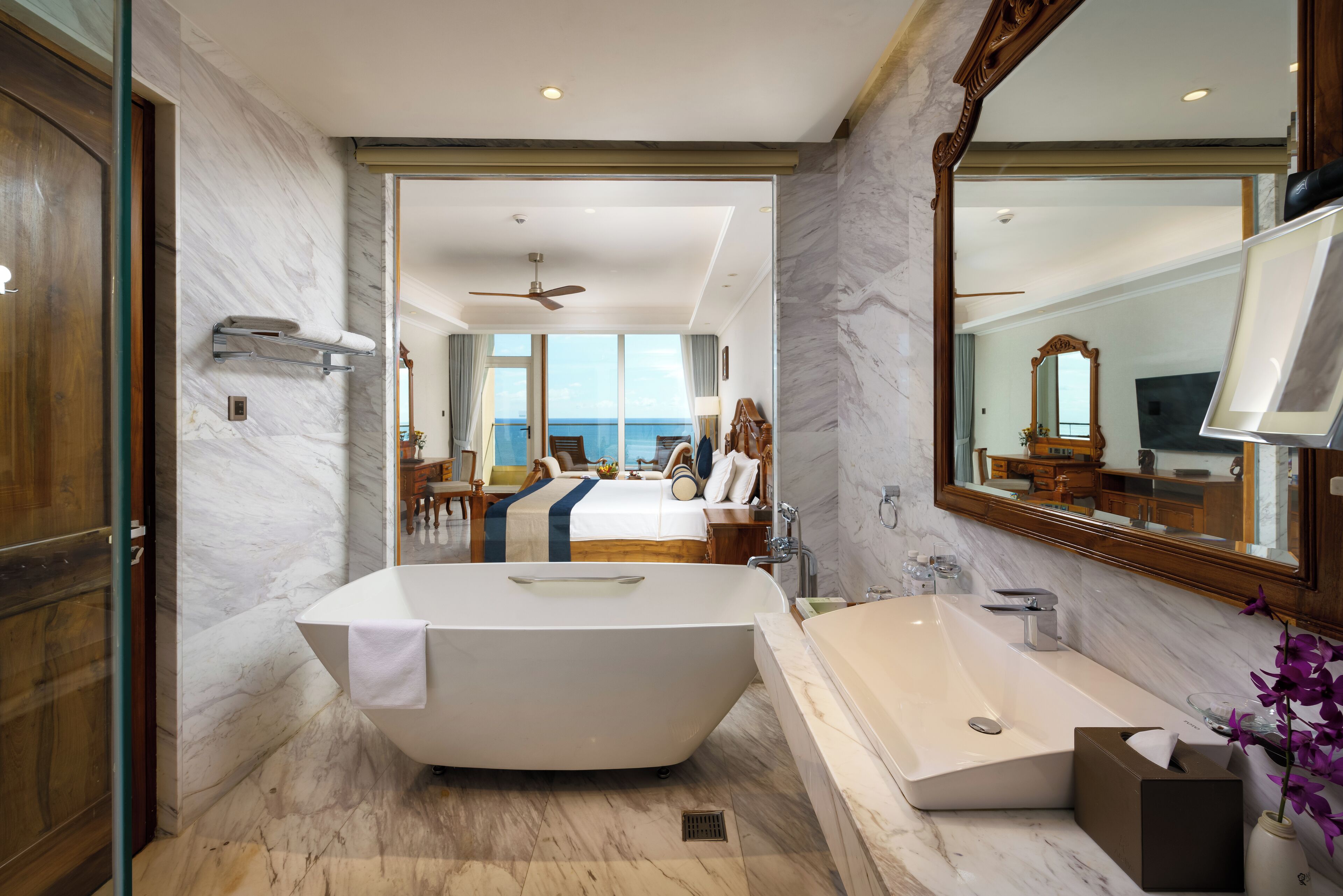 A modern bathroom with a freestanding bathtub, a separate sink, and a large mirror.