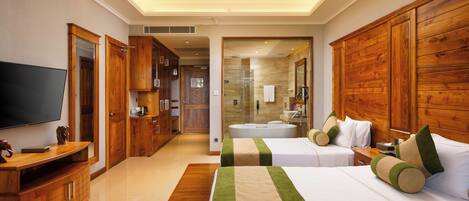 Habitación de hotel con televisión, muebles de madera, cama con ropa de cama verde y beige, y baño con bañera y ducha.