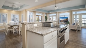 A spacious kitchen with a dining area, large windows, and a view of the city. - Stunning ocean block condo with 5 bedrooms and 4 and 1/2 baths! (Ocean City)
