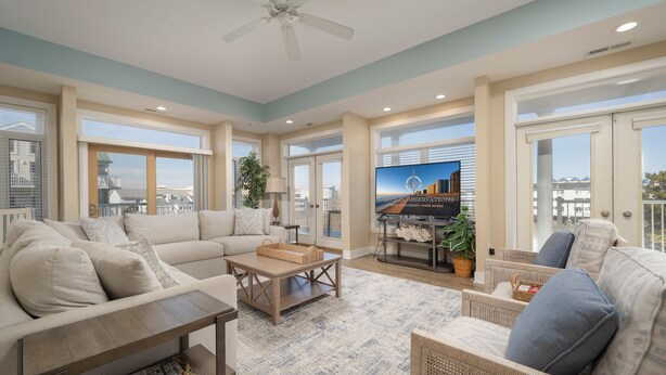 A spacious living room with a large sofa, a coffee table, and a television. - Stunning ocean block condo with 5 bedrooms and 4 and 1/2 baths! (Ocean City)
