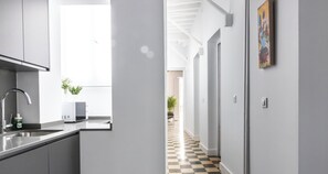 A modern kitchen with a sink, a microwave, and a potted plant.
