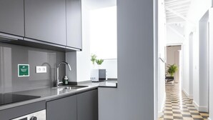 A modern kitchen with grey cabinets, a stainless steel sink, and a microwave.