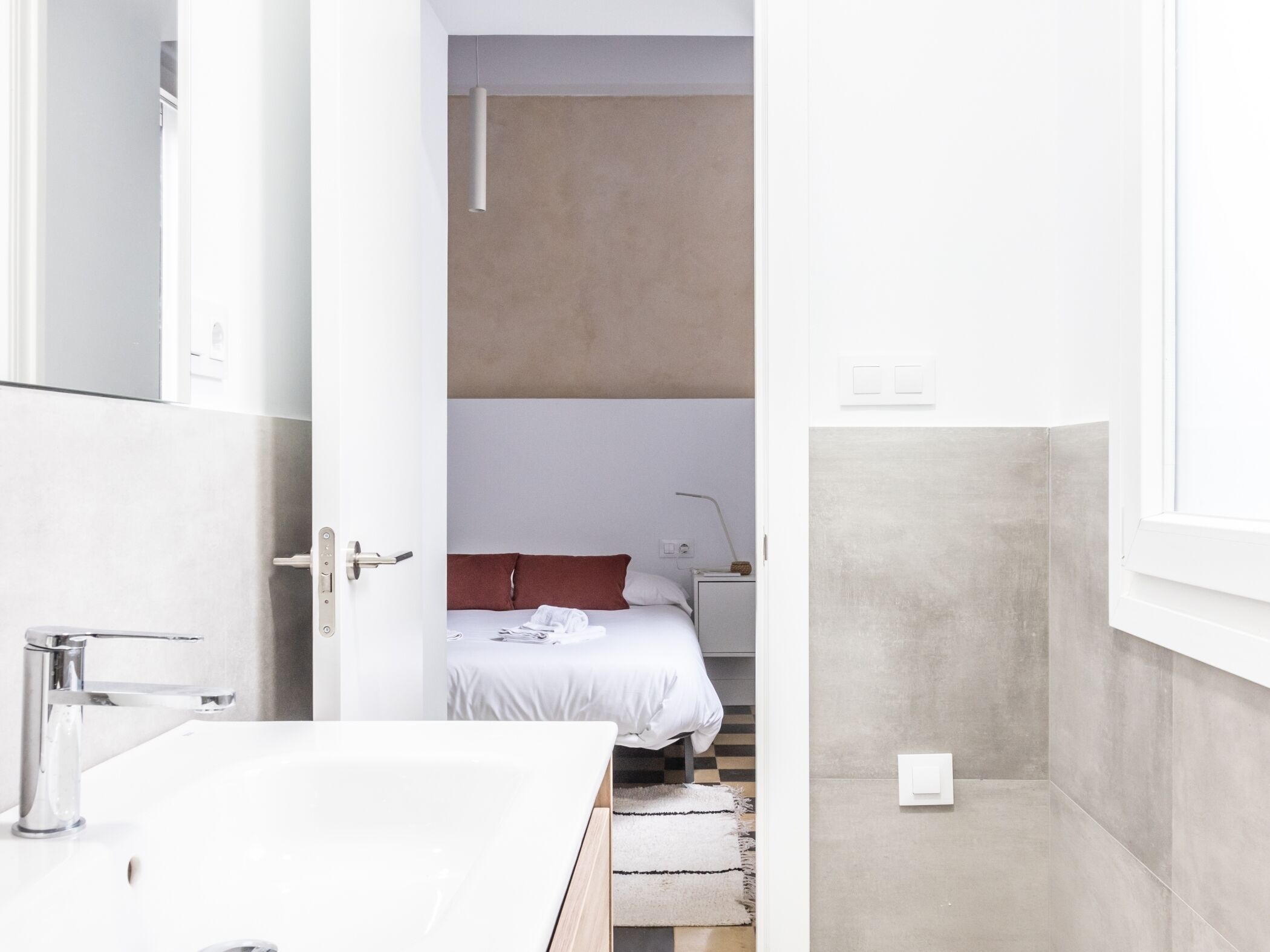 Un baño moderno con lavamanos blanco, grifo cromado y toallero visible.