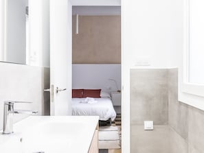 A modern bathroom with a white sink, chrome faucet, and a visible towel.