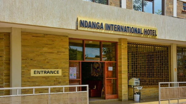 The exterior of Ndanga International Hotel with an entrance sign, a reception desk, and a security gate. - Ndanga International (Ruiru)