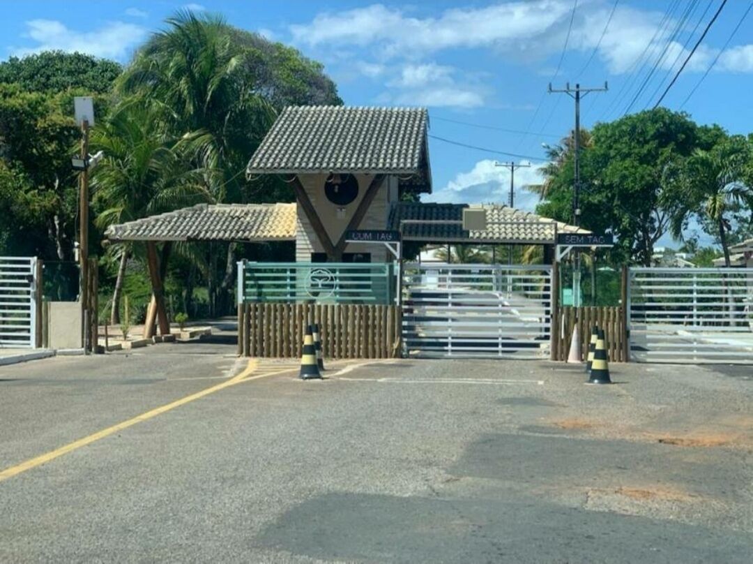 Una entrada protegida por una reja metálica y un pequeño edificio con techo de tejas.