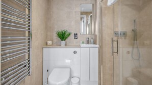 Une salle de bain moderne équipée de toilettes, d’un lavabo et d’une douche.