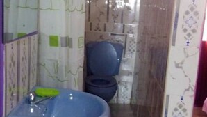 Un baño con un lavabo azul, un inodoro y paredes con diseño.