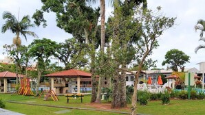 A resort with a swimming pool, outdoor seating, and a playground.