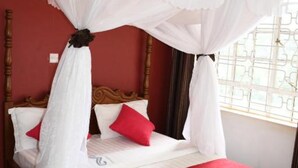 A bed with a canopy, red pillows, and a red blanket. - Monalisa Hotel Thika (Thika)