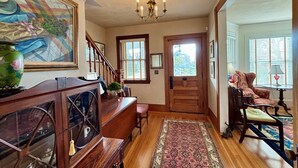 A traditional interior with a wooden staircase, a dining area, and a living room with a patterned rug. - Charming home in downtown Chatham (Chatham)