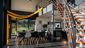 Ein modernes Interieur mit Essbereich, Küche und Treppe.