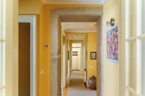 Stunning hallway with a decorative vase and a door leading to a room.