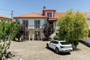 Traditional architecture meets serene surroundings in this charming two-story building with a red-tiled roof and central courtyard.