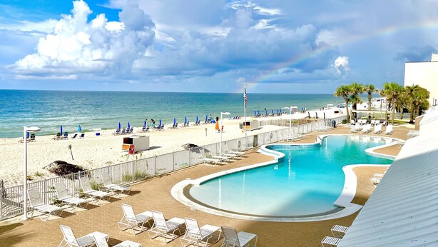 Un complexe hôtelier doté d’une piscine, d’une plage et offrant une vue sur l’océan.
