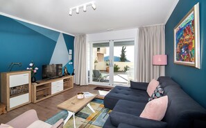Premium appartement | Woonkamer | Een 104-cm lcd-televisie met digitale zenders en televisie