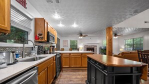 A kitchen with wooden cabinets, a central island, and a dining area with a couch.