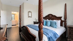 A four-poster bed with a wooden headboard, a blue throw blanket, and matching nightstands. - Windsor Palms 3 Bed Condo In Gated Resort 3 Bedroom Condo by RedAwning (Kissimmee)