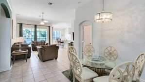 A spacious living area with a dining table and chairs, a sofa, and a ceiling fan. - 4 Bedroom/3 Bath South Facing Pool/Spa Villa 4 Villa by RedAwning (Kissimmee)