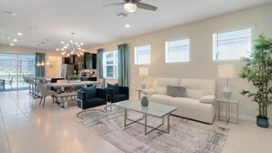 A modern living room with a sofa, coffee table, and dining area.