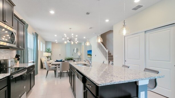 A modern kitchen with granite countertops, stainless steel appliances, and a central island.