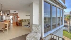 Un appartement moderne doté d’un grand balcon, d’une cuisine équipée d’appareils électroménagers en acier inoxydable et d’un espace de vie comprenant un canapé et une table à manger.