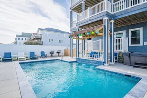 Relax by the pool surrounded by a spacious deck with lounge chairs and a barbecue grill.