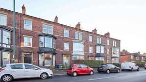 A row of terraced houses with a street in front.