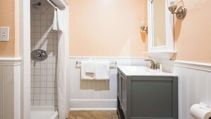 Une salle de bain avec une douche, un lavabo et un miroir.