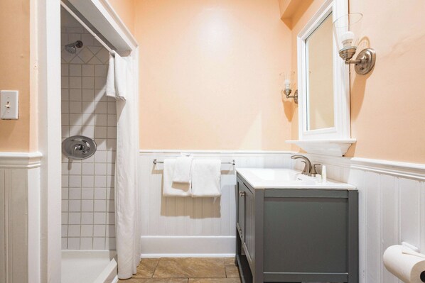 Un bany amb dutxa, un lavabo i un mirall.